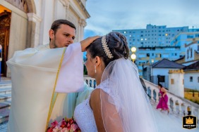 A heartwarming moment captured outside the Basílica Nossa Senhora das Dores in Porto Alegre, Brazil, as the priest prays with the bride before the wedding ceremony.